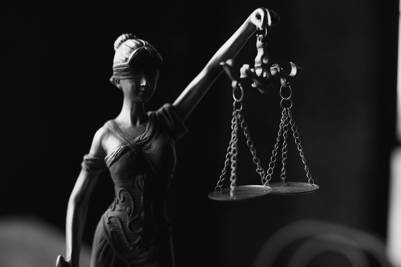 The Art of Drawing Readers In: Your attractive post title goes here A close-up black and white photo of the Lady Justice figurine with scales.